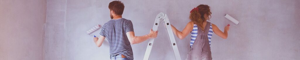 Couple painting a room with rollers and a ladder, representing the best types of loans for home improvements.